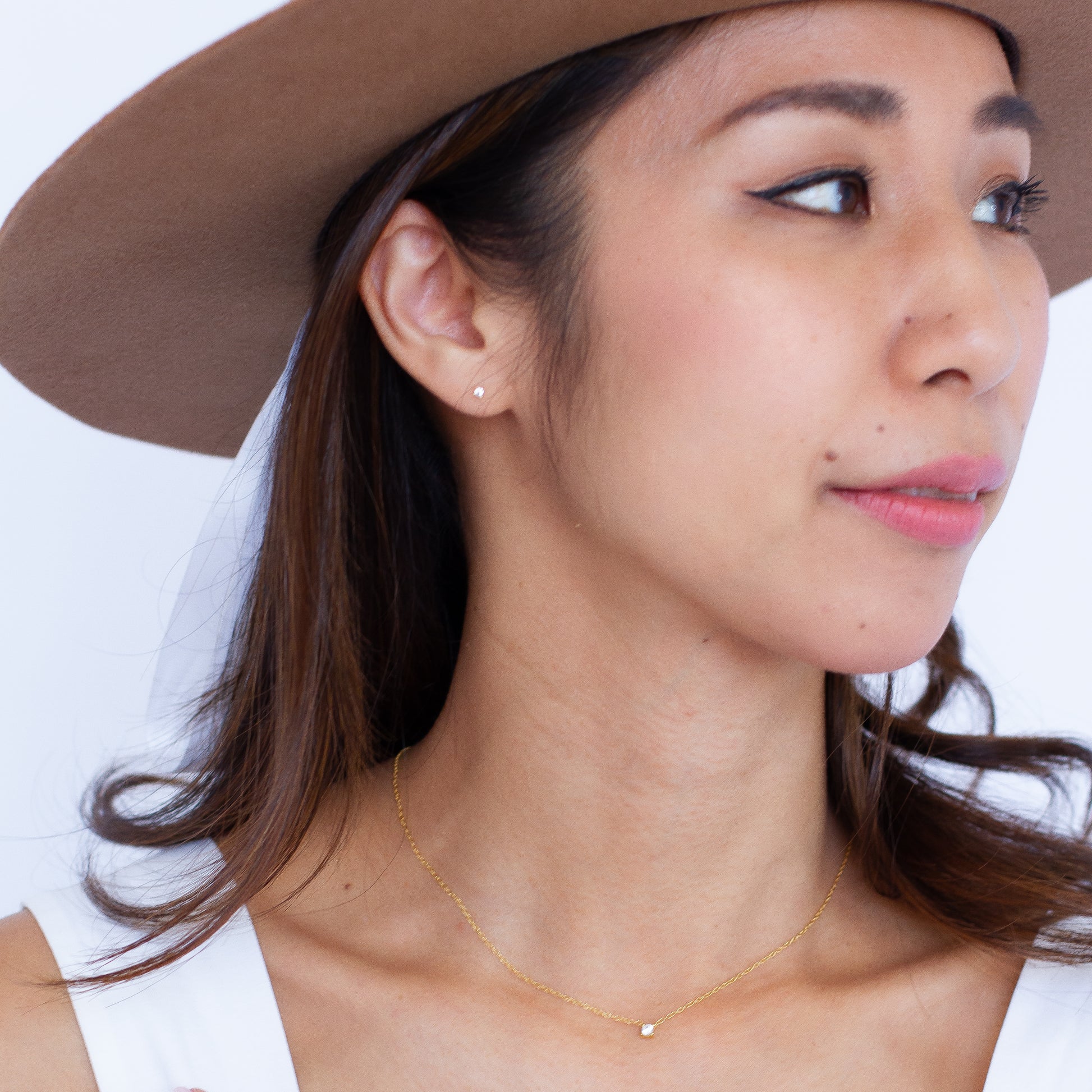 Model wearing dainty 2mm cubic zirconia studs